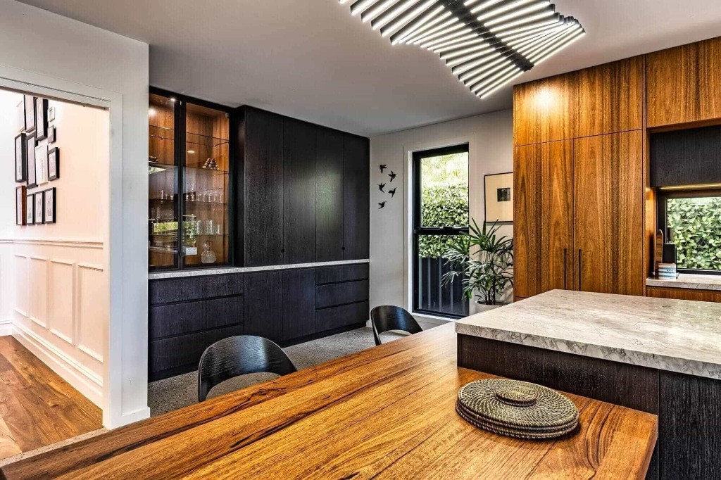 Luxury dining and kitchen with custom cabinetry and sculptural lighting